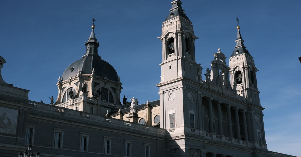 Majestic view of the Almudena Cathedral lit by the sun in Madrid, Spain. Ideal for travel and architecture enthusiasts.